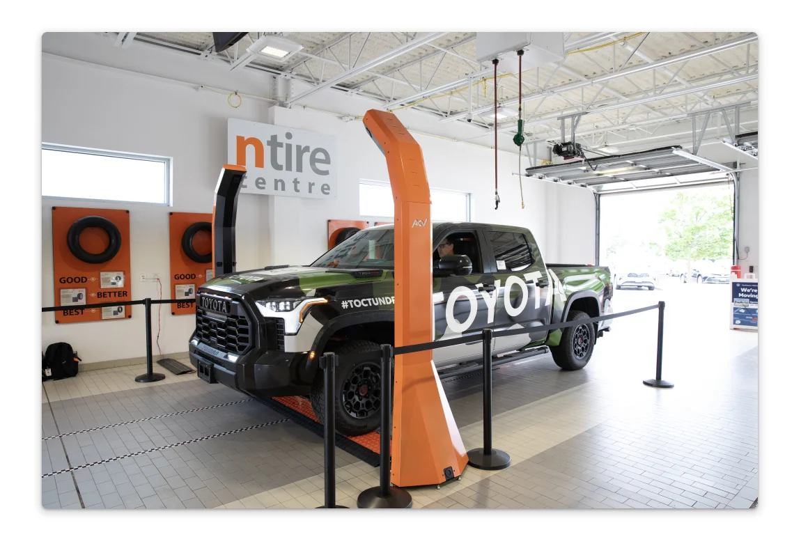 Viper, the orange inspection hardware, next to a truck in a dealership service bay